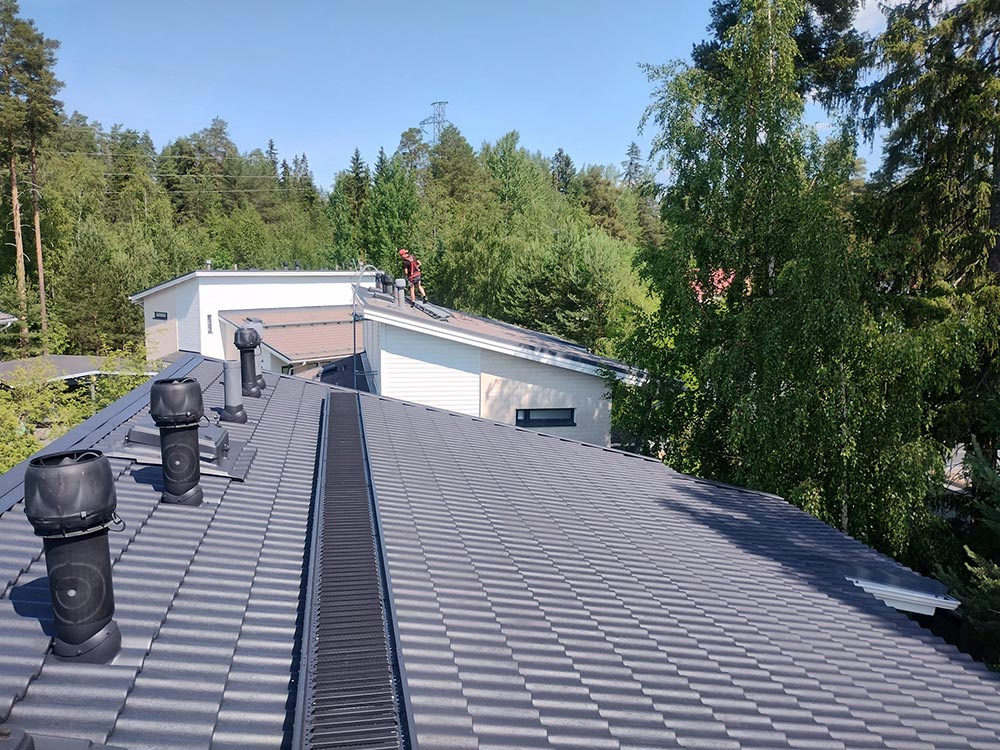 Edustalla pinnoitettu katto ja taustalla pinnoittamaton katto
